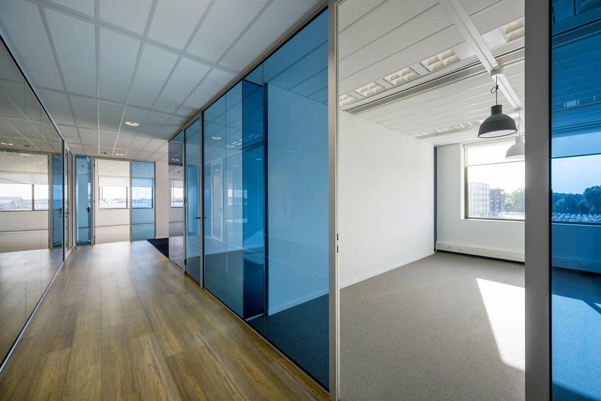 Licht en modern kantoorpand op Rotterdam Airportplein met glazen wanden en uitzicht op de stad.